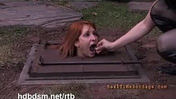 A cute redhead slave gets covered with mud and piss outdoor